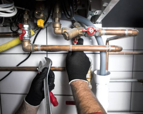 plumber working at home, work at the heating installation